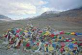 Ladakh - pile of stones on  mountain pass with the characteristc prayer flags 